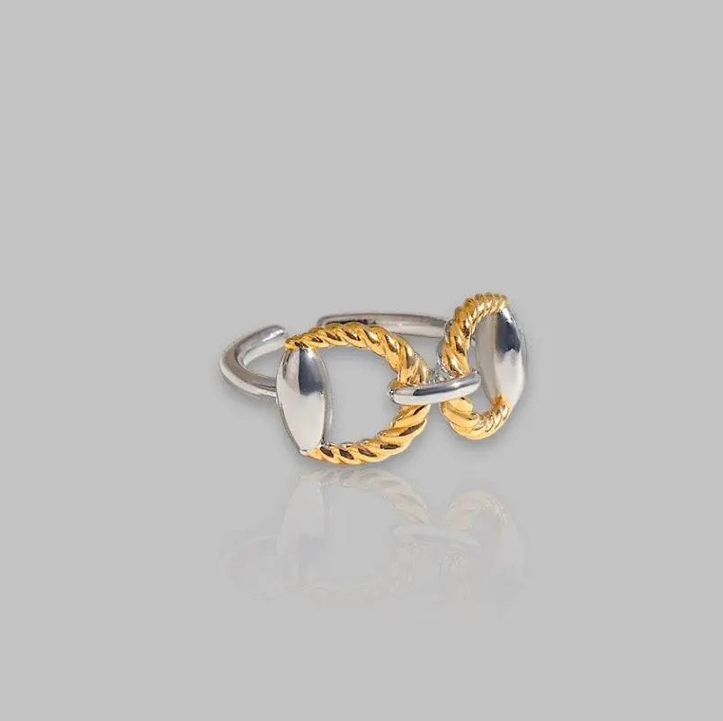 Eleganter Chunky-Ring mit goldenen und silbernen Details, verziert mit geflochtenem Design. Stilvolles Schmuckstück für moderne Looks.