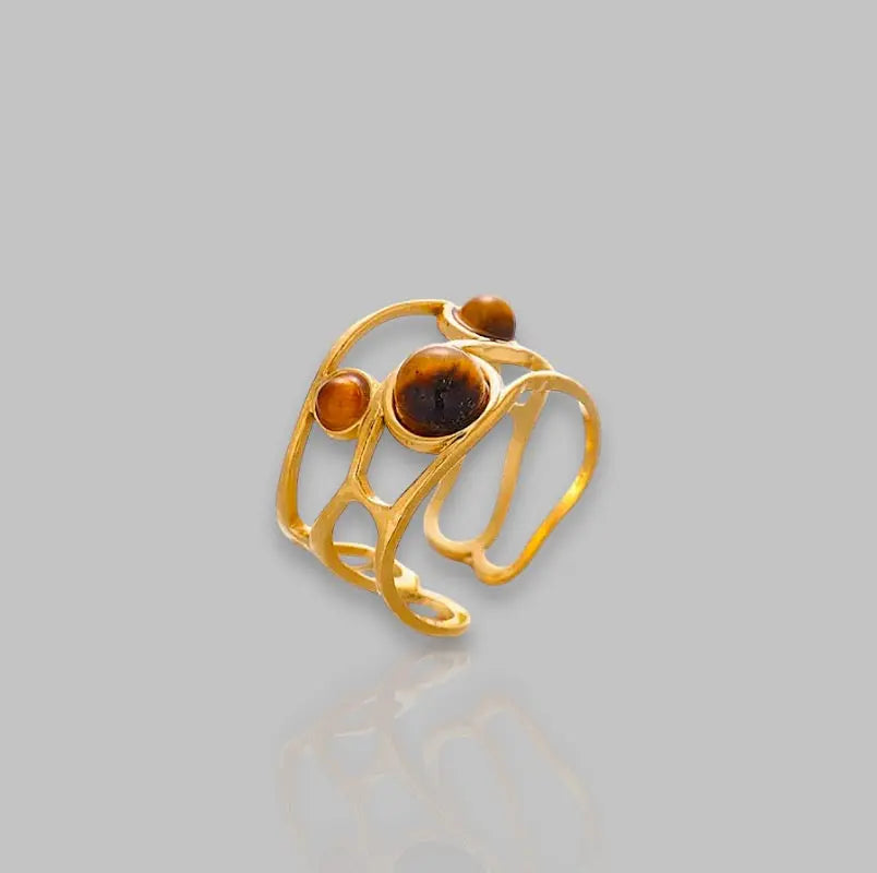 Eleganter goldener Ring Luna mit drei bernsteinfarbenen Steinen und offenem Design. Stilvolles Schmuckstück für besondere Anlässe.