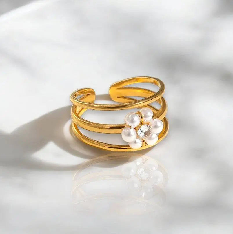 Eleganter goldener Ring mit Faux-Perlen und funkelndem Kristall in Blumenform. Stilvolles Schmuckstück für besondere Anlässe und Alltagslooks.