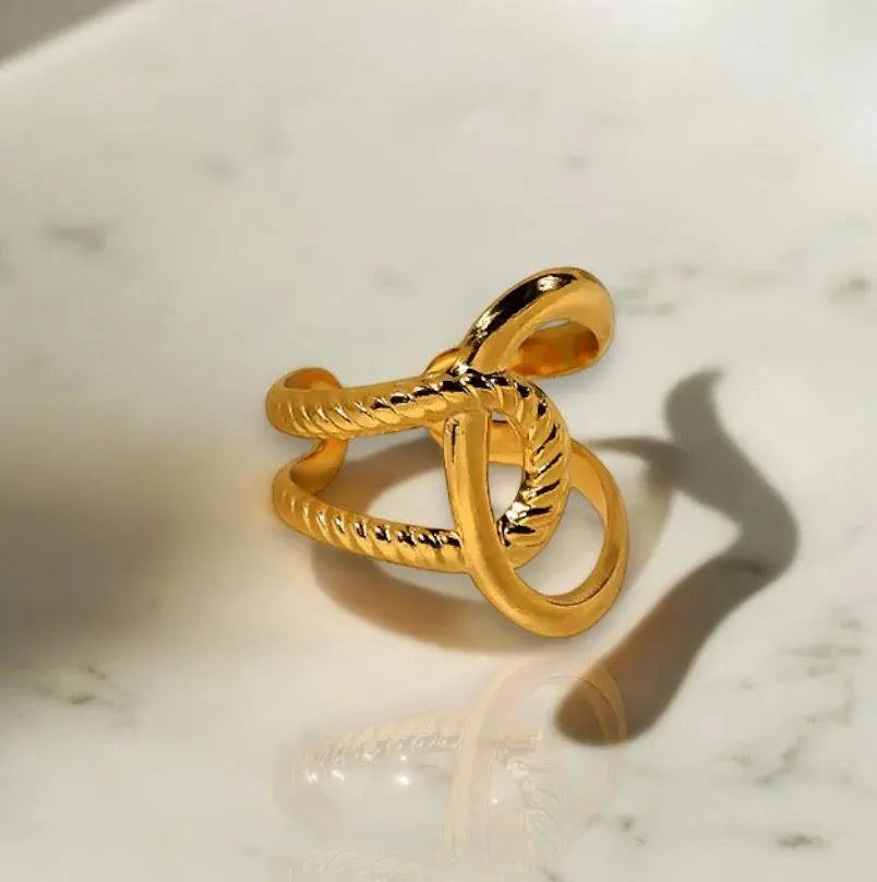 Eleganter Twist Charm Ring aus goldfarbenem Metall mit kunstvollem, verdrehtem Design. Perfektes Schmuckstück für individuellen Stil und Ausdruck.