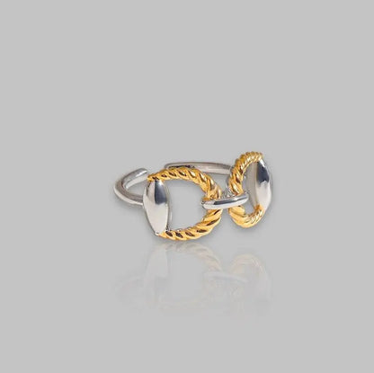 Eleganter Chunky-Ring mit goldenen und silbernen Details, verziert mit geflochtenem Design. Stilvolles Schmuckstück für moderne Looks.