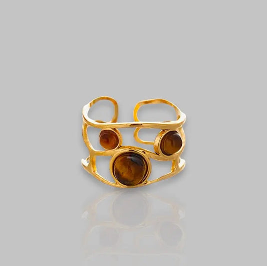 Eleganter goldener Ring Luna mit drei bernsteinfarbenen Steinen und offenem Design. Stilvolles Schmuckstück für besondere Anlässe.