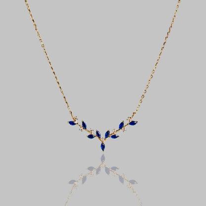 Elegante Halskette 'Deer Antler' mit goldener Kette und blauen Edelsteinen in Geweihform. Stilvolles Schmuckstück für besondere Anlässe.
