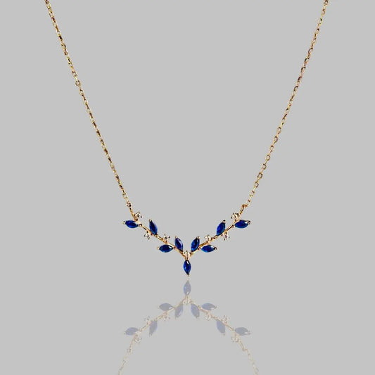 Elegante Halskette 'Deer Antler' mit goldener Kette und blauen Edelsteinen in Geweihform. Stilvolles Schmuckstück für besondere Anlässe.