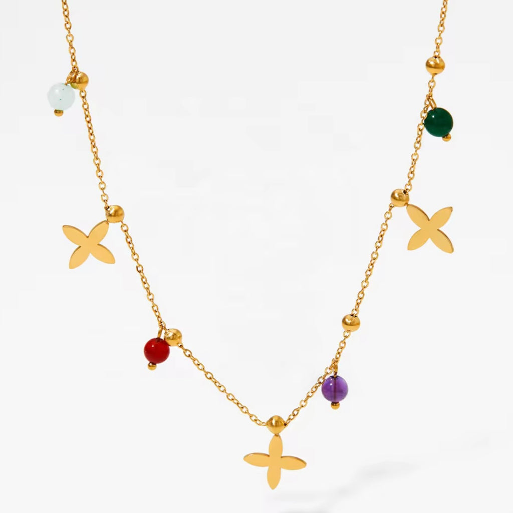 Primavera Halskette mit Blütenanhängern und bunten Perlen an goldener Gliederkette (Rot, Grün, Lila, Hellblau).