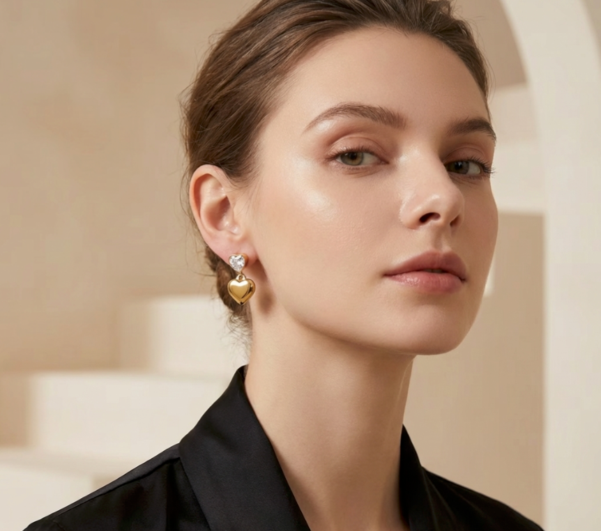Diamond Kiss Ohrringe: goldene Herzanhänger mit Diamant am Ohr getragen.