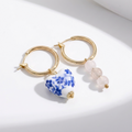 Blue Belle Ohrringe: goldene Hoop-Ohrringe mit blauweißem Porzellanherz und drei rosafarbene Perlenanhänger