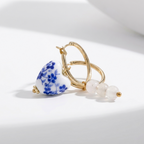 Blue Belle Ohrringe: Goldene Creolen mit herzförmigem Porzellananhänger in Blauweiß-Blumenmuster und weißen Perlen.