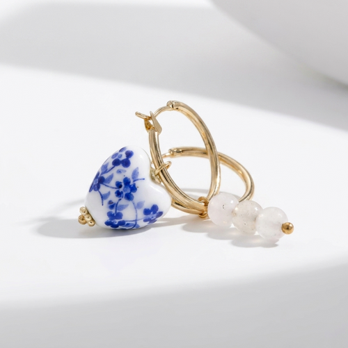 Blue Belle Ohrringe: Goldene Creolen mit herzförmigem Porzellananhänger in Blauweiß-Blumenmuster und weißen Perlen.