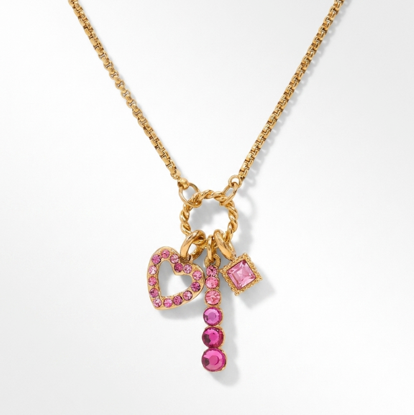 Pink Spark Halskette mit goldener Kette und drei pinken Anhängern: Herzrahmen, senkrechter Steinanhänger und Quadrat.