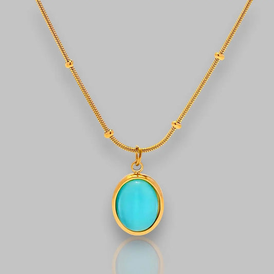 Halskette "Turquoise Serenity" mit ovalem Anhänger in strahlendem Türkis und goldfarbener Kette.