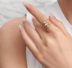 Eleganter goldener Ring Shelly mit filigranen Details und drei weißen Schmucksteinen. Stilvolles Accessoire für besondere Anlässe.
